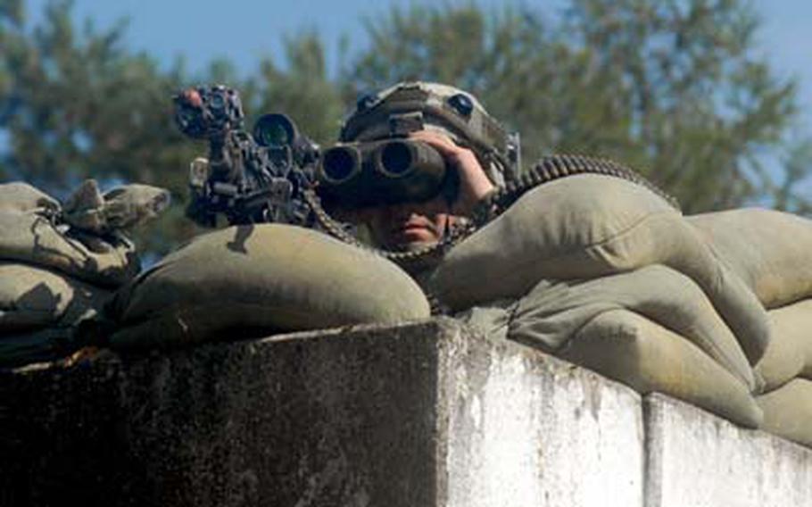 173rd Airborne Brigade Spc. Trevor Michalak, 23, of Cinnaminson, N.J., watches for trouble from a gas station roof inside “The Box” training area at Hohenfels’ Joint Multinational Readiness Center on Monday.
