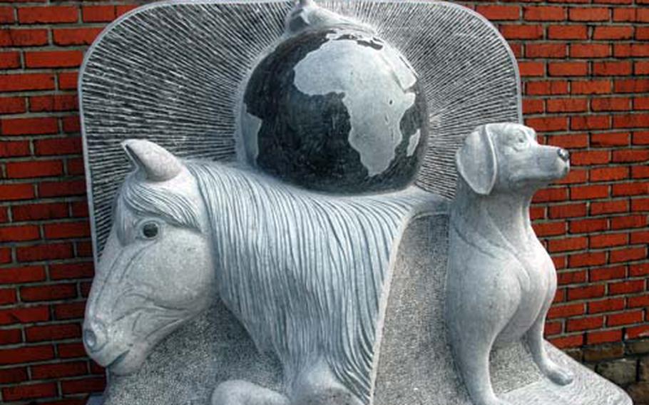 The relief sculpture includes a horse, homing pigeon and dog, foreground. About 150 people attended the event, including members of the U.S. Army Europe band and an honor guard from the 1st Infantry Division.