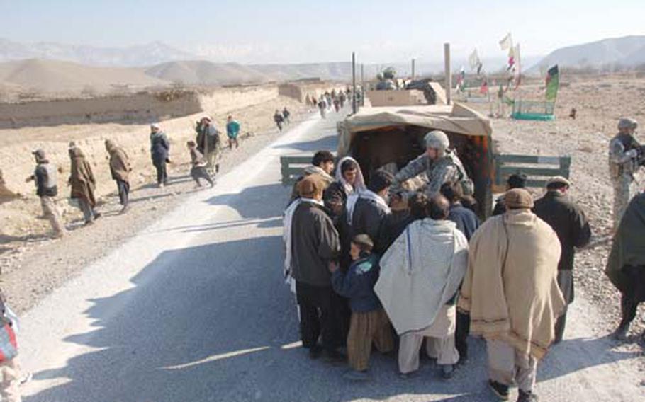 Villagers receive humanitarian aid from the Bagram Provincial Reconstruction Team in Kapisa province, Afghanistan, in January 2008.