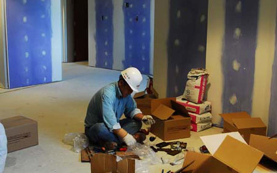 A construction worker assembles parts inside the Wolfpack Lodge, scheduled to open in December. The 200-room lodge is one of 44 construction projects under way at Kunsan and will replace the aging 104-room hotel now used to house visitors as well as arriving and departing personnel.