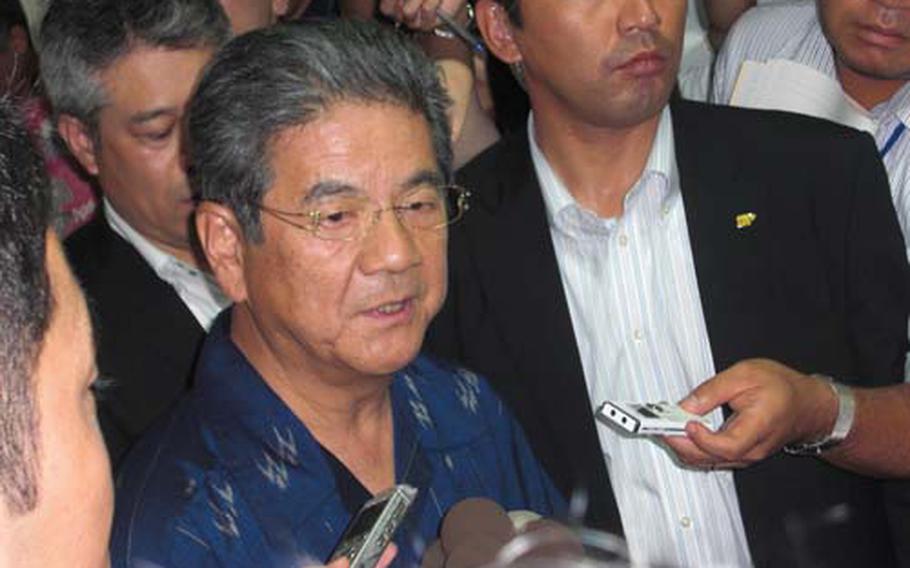 Japan Defense Minister Toshimi Kitazawa is surrounded by reporters Friday following his meeting with Okinawa Gov. Hirokazu Nakaima in Naha. Kitazawa is on a fact-finding visit to gather input on plans to move U.S. air operations from Marine Corps Air Station Futenma.