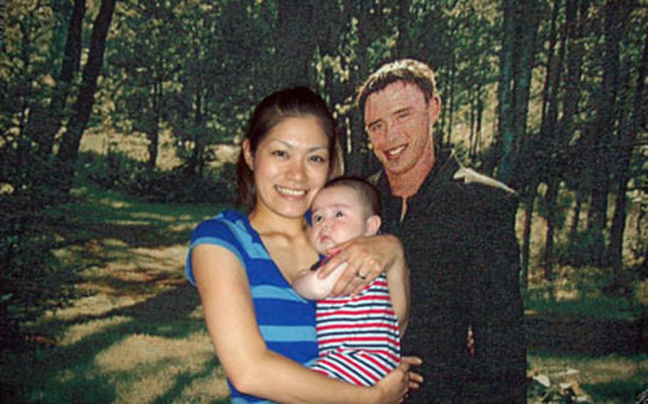 Hotaru Ferschke and son Mikey pose in front of a blanket bearing a photo of her husband, Sgt. MIchael Ferschke, who was killed in Iraq last year. She is fighting an immigration law that prevents her from living in the U.S. permanently and raising their son with the Ferschke familiy in Tennessee.