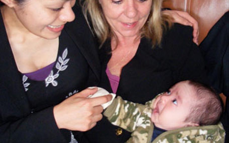 Mikey Ferschke smiles at his mom, Hotaru, and grandmother Robin after a memorial service for his father, Marine Sgt. Michael H. Ferschke Jr., in February. Mikey and his mom have been living with his grandparents in Maryville, Tenn., but might be forced to return to Okinawa because of U.S. immigration laws.
