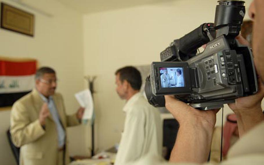 A cameraman with the Diyala Media Center films a report on the mayor of Canaan.