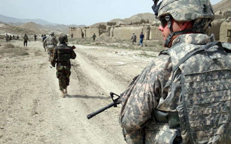 Spc. William Bolling, a chaplain’s assistant, walks on patrol in April with the Afghan Border Police’s 2nd kandak (battalion) in Chamkani, Paktia province. U.S. soldiers are training the border police in basic tactics