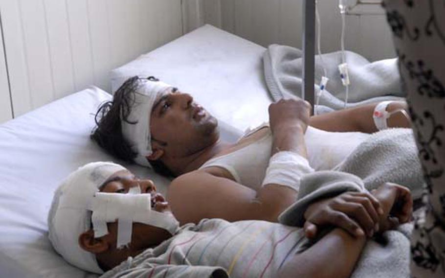 Cousins Sameem Kareem, 14, left, and Nakhybullah Haydur, 20, share an emergency room bed after being wounded in a powerful bomb blast outside the Afghan Ministry of Interior and the Indian Embassy in Kabul. The two cousins, who were sitting outside their family's photo shop at the time of the bombing, had both been injured in another bombing in the capital two years ago.