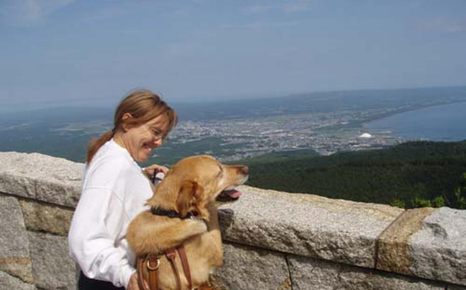 Karen Howard and her service dog, Oliver, look out over Mutsu Bay in Aomori Prefecture, Japan. Howard moved to Misawa, Japan, in 2007 with her family after her husband, Bryan, got a three-year assignment to Misawa Air Base. Krean Howard has a neurological condition that affects her balance and speech; she needs Oliver to help her get around.