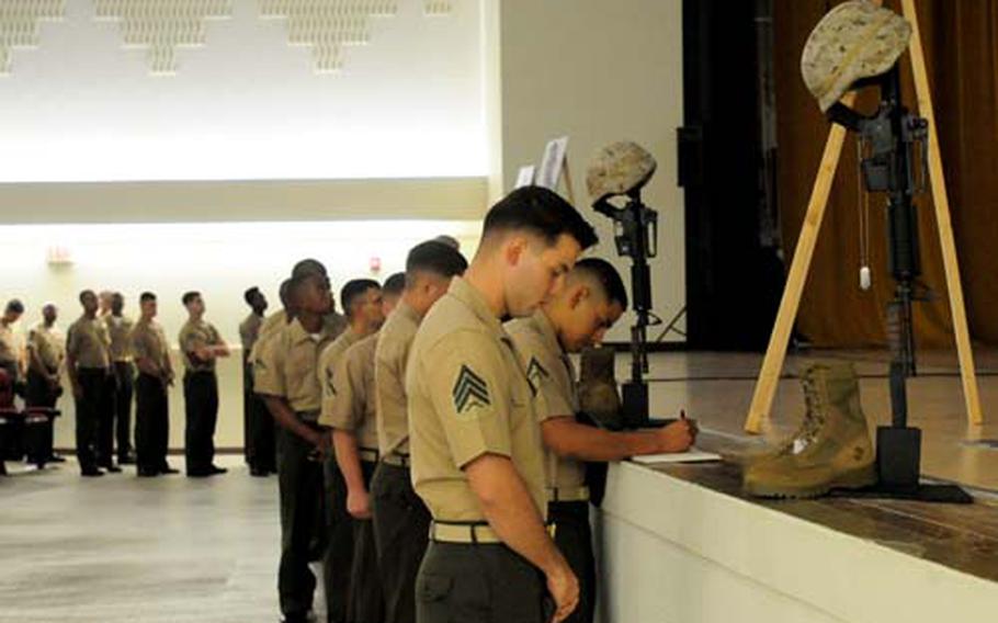 Friends and family members gathered at the Camp Hansen Base Theater on Okinawa Thursday to pay their respects to the three Marines and sailor that were killed Sept. 8 while part of an embed team that was training with the Combined Security Transition Command in the Sarkani District of Kunar province.