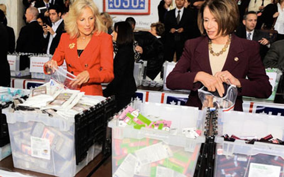 Jill Biden, left, and Nancy Pelosi help stuff the first USO care packages tailored toward women. The new packages include items such as makeup and hair care products.