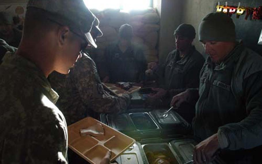 Capt. Jason Wingeart, commander for Company B, 1st Battalion, 32nd Infantry Regiment and other company officers serve Thanksgiving chow at the austere Combat Outpost Charkh in Logar province, Afghanistan.