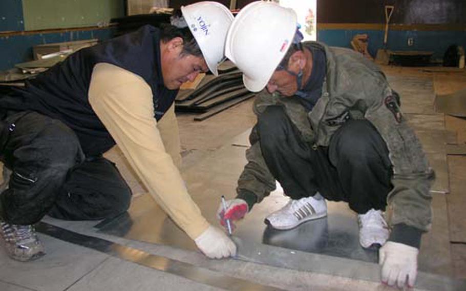 At Camp Humphreys in Pyeongtaek, South Korea Wednesday, workers are refurbishing a gym that will be set aside for use by the post’s growing teen population. Work is to finish in January. Measuring metal for a new ventilation system are Yi Yong-mi, left, and Jong In-ji.