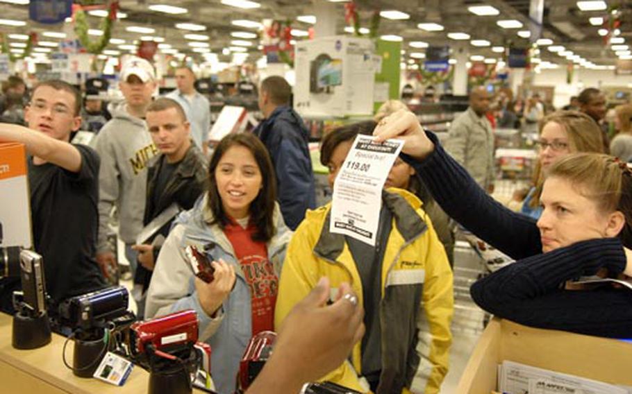 Air Force Tech. Sgt. Shannon Cagler, right, from Naples, Italy, shows her ticket to redeem a blue ray disc player early in the morning on "Black Friday" at the Kaiserslautern Military Community Center on Ramstein Air Base, Germany.