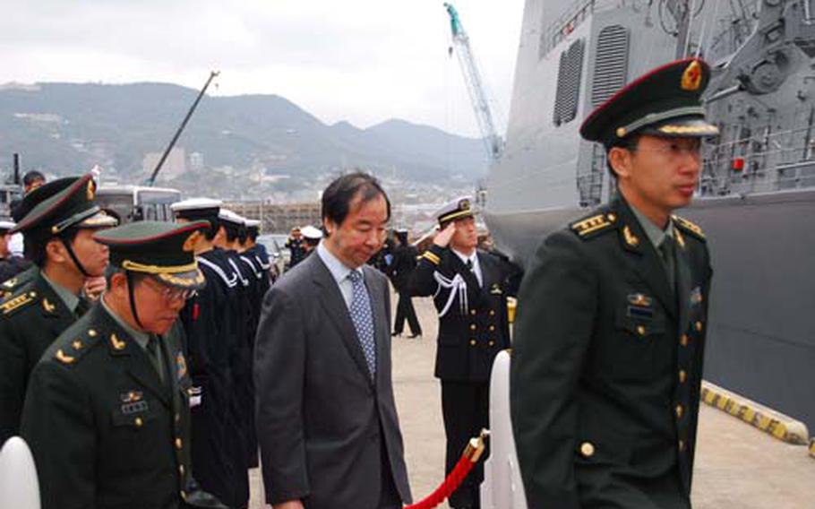 Officers from China’s defense ministry board the Japanese destroyer Chokai at Sasebo Naval Base on Monday. The warship is equipped with the U.S.-developed Aegis weapons system, which gives the U.S. an edge over China’s rapidly developing missile program.