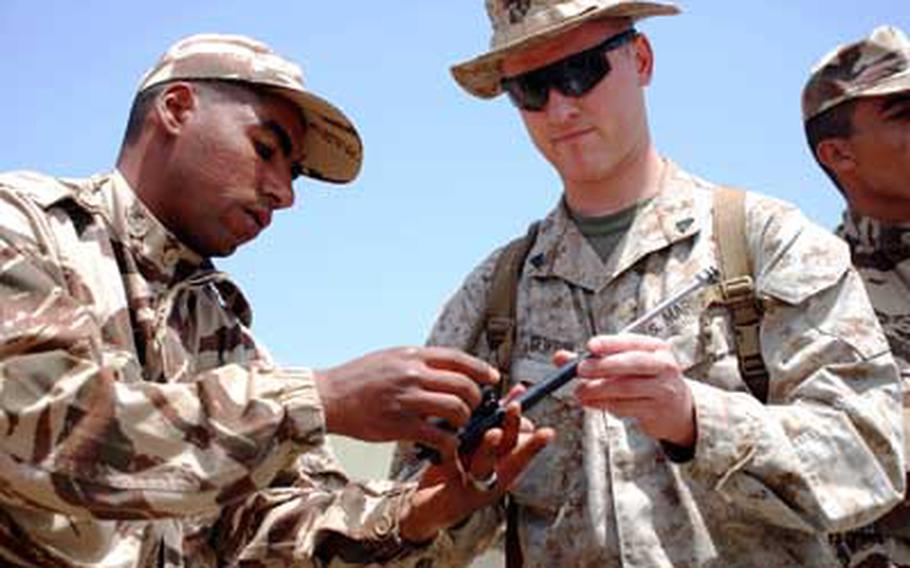 Marine Cpl. Rory C. Newton, right, inspects the bolt of a Moroccan AK-47 service rifle with the help of a Moroccan soldier during Exercise African Lion in June.