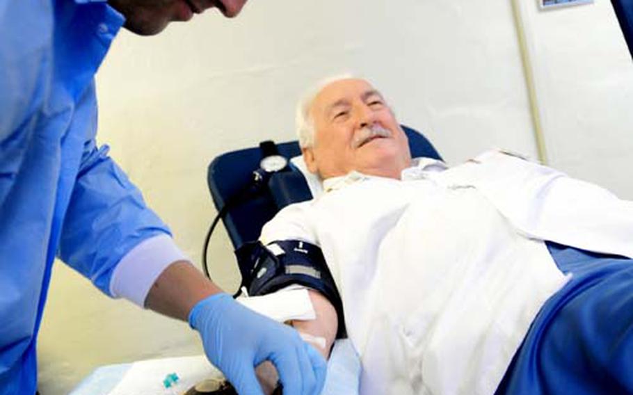 Petty Officer 3rd Class Jason Schrunk prepares to complete the blood drawing process as 76-year-old retired Air Force Staff Sgt. Dennis Provencher donates his 34th recorded gallon of blood Thursday at the American Red Cross Center on Camp Foster. Provencher has been regularly donating blood since arriving on Okinawa in 1961 and is currently recognized by the Guinness Book of World Records as donating more blood than anybody else.