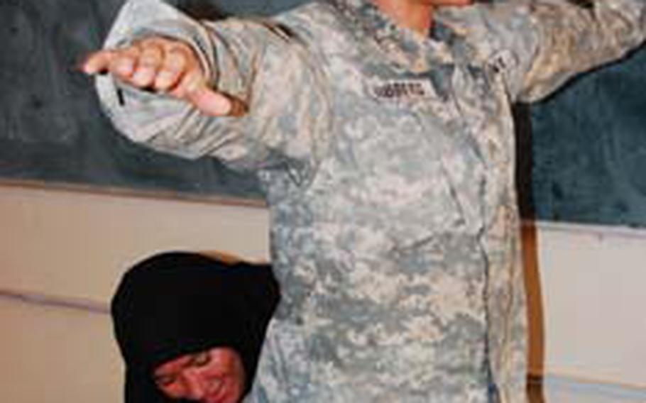 Hozei Jasim, a "Daughters of Iraq" and widow with five children, practices search techniques on Sgt. Frankie Hibberd, of 150th Armored Reconnaissance Squadron, 30th Heavy Brigade Combat Team, on June 12, 2009.
