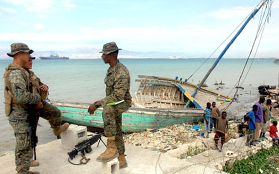 From left, Lance Cpl. Jeffrey Czarnec, Lance Cpl. Frank Plummer and Sgt. Antwan Jones stand on the waterfront at Carrefour on Tuesday.
