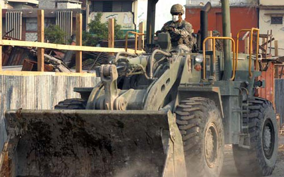 A U.S. soldier, wearing a mask to protect him from dust, clears earthquake rubble from Port-au-Prince in late February.