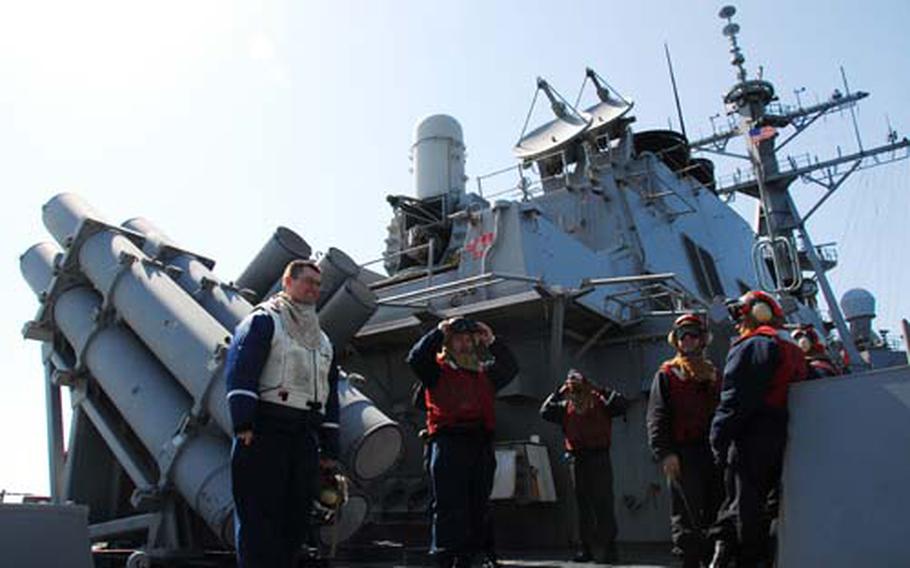 Crew members of the USS Curtis Wilbur wait for the arrival of a helicopter on Saturday. The Curtis Wilbur is one of four U.S. ships standing by to assist in a rescue efforts to get to 46 South Korean sailors missing after the South Korean ship Cheonan sank on March 26. Most of the South Korean and U.S. ships at the wreckage site are also there as a deterrent to nearby North Korea, according to the U.S. Navy officer in charge of the American forces there.
