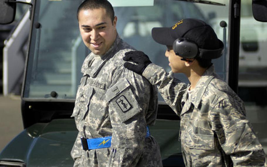 Cresencio Santos, 15, gives his older brother, Army Pvt. Kevin Colindres, a loving slap on the shoulder during a visit Tuesday to Ramstein Air Base's flightline.
