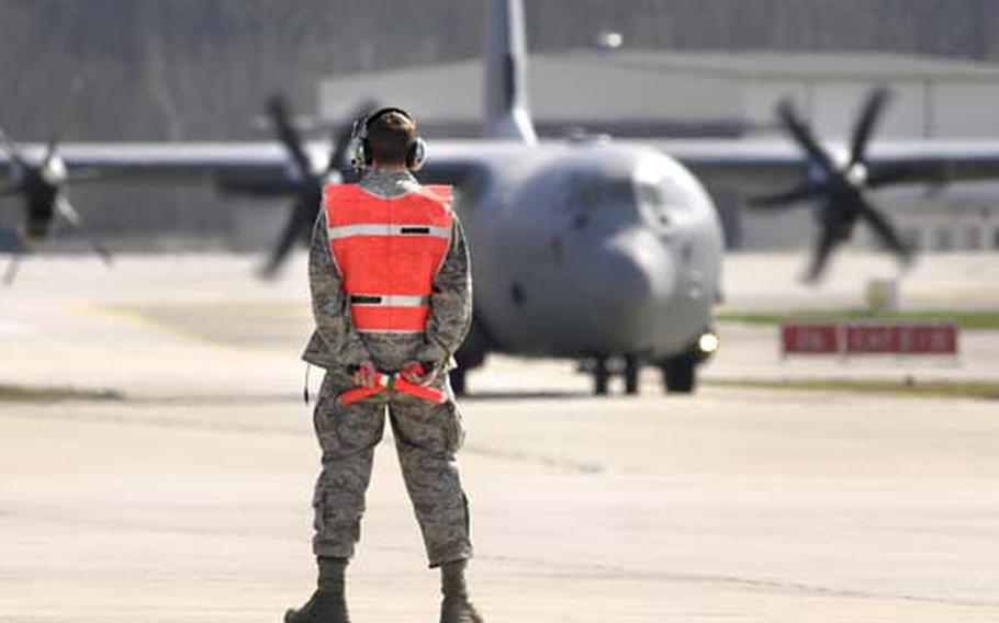 Airman 1st Class Paul Driscoll, a hydraulics specialist, readies to direct in a C-130J on Ramstein Air Base's flight line in April 2009 .