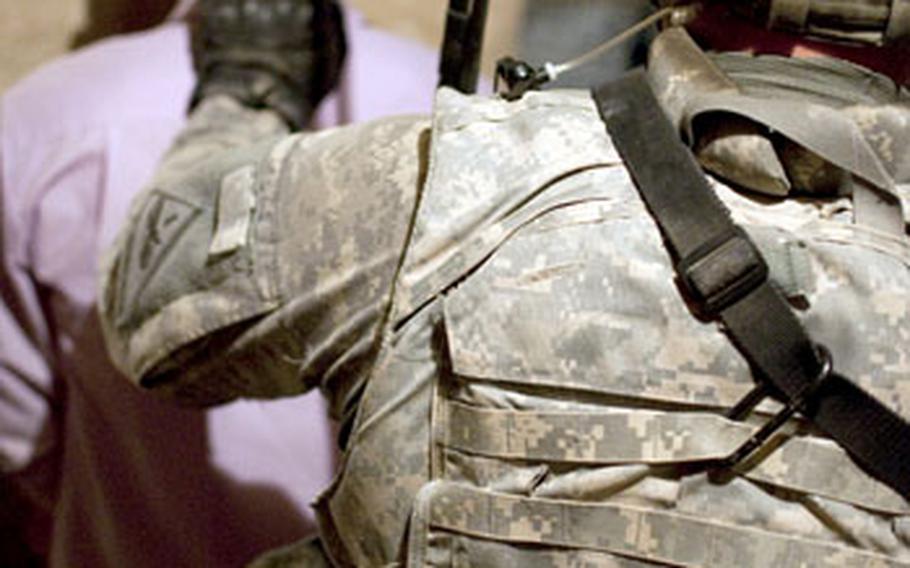 A U.S. soldier keeps control over a man arrested by Iraqi police after they obtained a video of him preparing to fire a rocket on a U.S. base. The police said they believed the man was a member of al-Qaida.