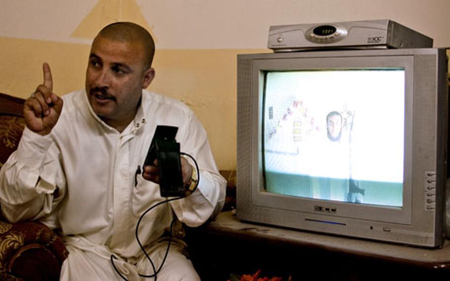 Iraqi Police Sgt. Maj. Jassim Mohammed Ali al-Tikriti shows American troops a cell phone video of a man apparently preparing to fire a rocket at a nearby U.S. base. Though violence has dropped precipitously in this one-time insurgent stronghold, the American base, FOB McHenry, takes incoming fire once or twice a week.