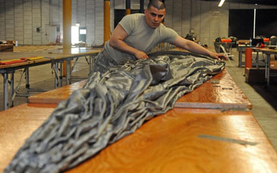 Sgt. Oscar Osorio, a parachute rigger with the 5th Quartermaster Detachment, 21st Theater Sustainment Command, packs a new MC-6 parachute at a warehouse on Rhine Ordnance Barracks in Kaiserslautern, Germany.