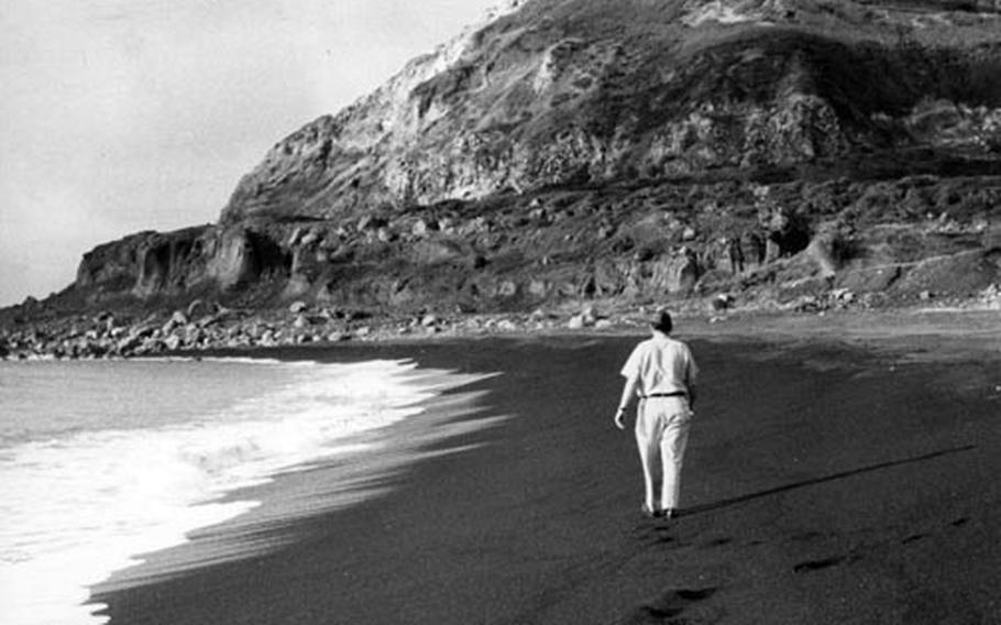 Air Force Capt. John S. Gunnison, who took part in the World War II invasion of Iwo Jima as a Marine 15 years earlier, walks along the beach toward Mt. Suribachi during his first visit to the island since the battle.
