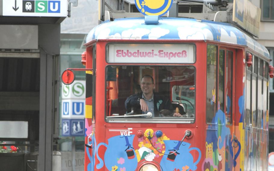 An Ebbelwei-Expess tram rolls into the main Frankfurt train station to pick up customers for its hourlong tour. Passengers can board the tram at 23 tram stops in Frankfurt. Most people start at the zoo tram stop or at the city's main train station.
