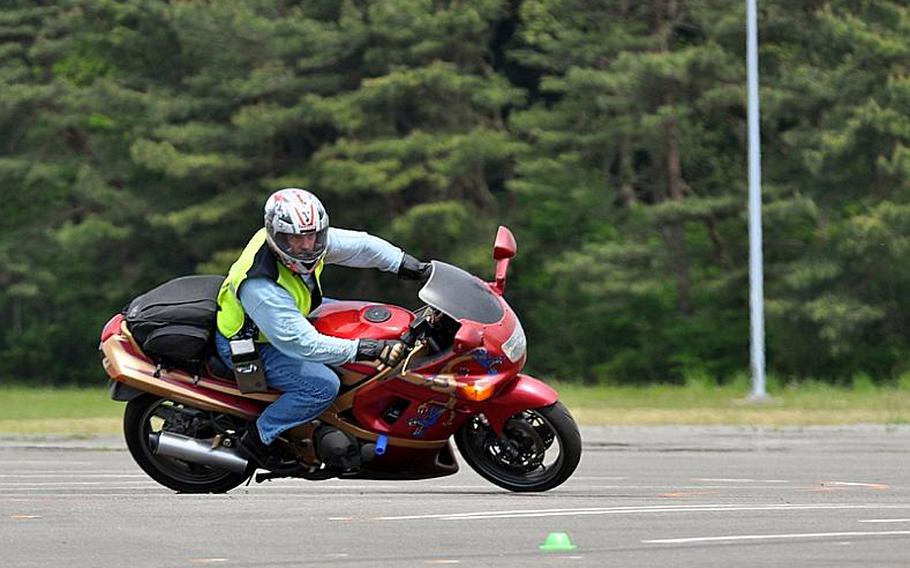 Navy Chief Eric Holewinski, a motorcycle mentor, demonstrates the proper way to keep control of a motorcycle through a series of tightening turns on Thursday at Naval Air Facility Misawa, Japan. NAF safety officials conducted a hands-on training course following the resumption of the riding season and a recent crash at Misawa.