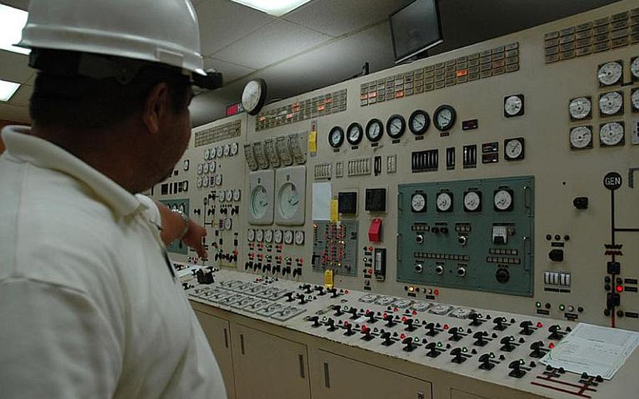 Frances Cruz, the assistant plant superintendent at the Cabras Steam Power Plant in Guam, points to a control panel during a tour of the plant in January. The island's system can generate enough power for the expected military buildup, with $110 million in upgrades to three turbines and distribution that the military is willing to support. Who will pay the $300 million needed to fix the island's sewage system is another matter. Still, an agreement signed last week by both parties pledged to keep local ratepayers from footing the costs of the military's plans.