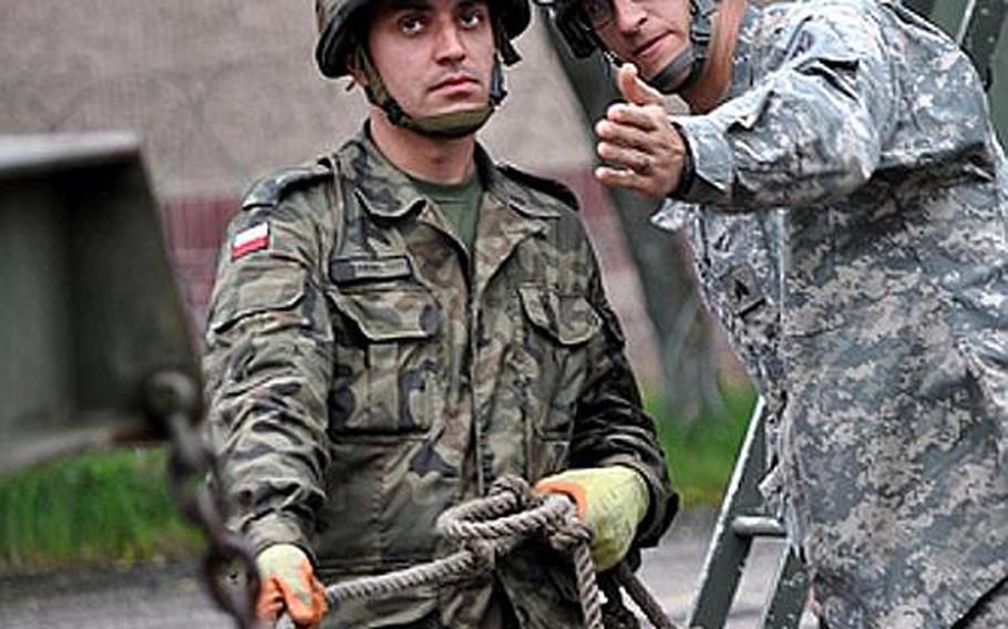 Polish air force Warrant Officer 3rd Class Tomasz Herc, left, and U.S. Army Sgt. Dustin P. Sigmon from Sherrills Ford, N.C., negotiate a Patriot missile canister during recent training in Morag, Poland. Soldiers from U.S. Army Europe's 5th Battalion, 7th Air Defense Artillery Regiment out of Kaiserslautern, Germany, are familiarizing the Polish military on the Patriot missile system. The training is designed to improve Polish air defense capabilities while also developing the skills of U.S. Patriot crew members.