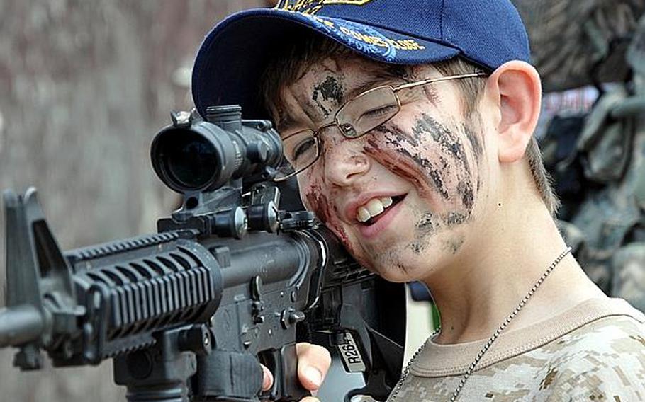 Jameson Singleton, 9, looks through the scope of an M4 carbine during Operation CODE on Saturday at Misawa Air Base, Japan.