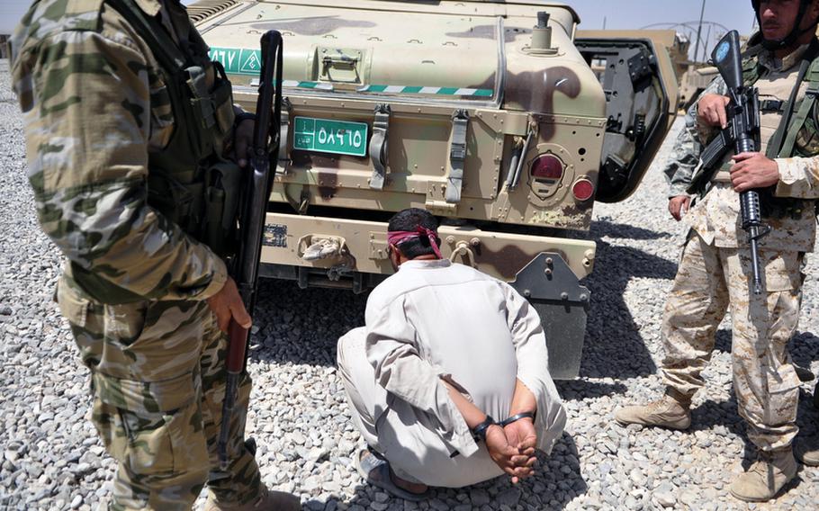 Iraqi soldiers stand over a suspected insurgent nabbed with the help of U.S. forces outside Mosul in August. While the Iraqi military has made strides fighting the country?s simmering insurgency, it is nowhere near ready to defend the borders. Heath Druzin/Stars and Stripes