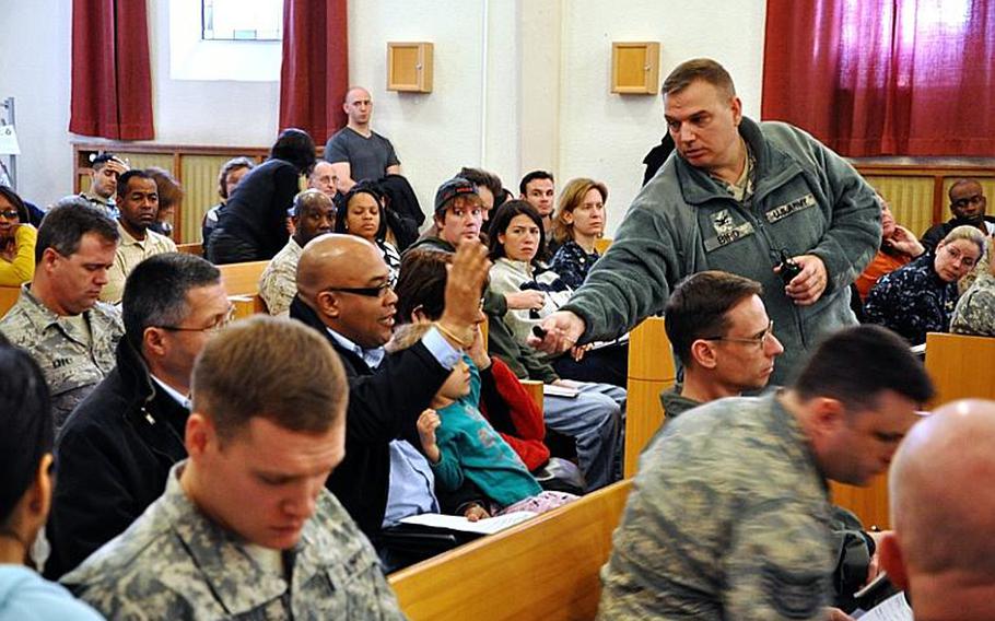 Col. Carl D. Bird, U.S. Army Garrison Stuttgart commander, takes questions from Defense Department personnel stationed in Stuttgart at the base chapel on Panzer Kaserne after a fire on Saturday destroyed nearly 100 families' shipments of household goods.