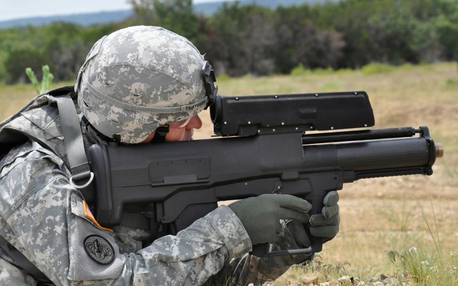 A soldier demonstrates the XM25 Counter Defilade Targeting Engagement System at Aberdeen Test Center, Md. The Army has begun testing and training with five of the prototype "smart" weapons in Afghanistan. The weapon fires rounds that can be programmed to explode on impact, in front of or behind an object. Limited production of the XM25 is expected to begin in 2012.