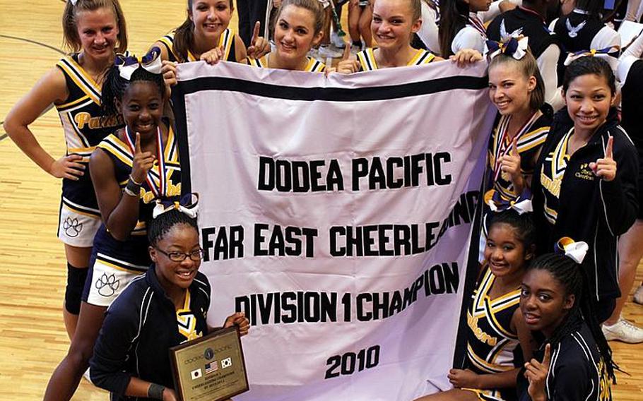 Members of Guam High's cheerleading team celebrate with the team banner Nov. 12 following the school's first Division I championship in the weeklong Far East competition at Matthew C. Perry High School, Marine Corps Air Station Iwakuni, Japan.