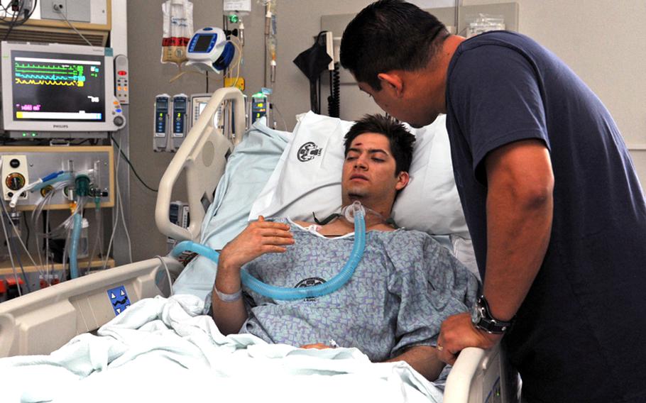 Pvt. Eric Griego talks to his dad Peter in the intensive care ward at Landstuhl Regional Medical Center on Nov. 9. Griego, 22, wounded in Afghanistan, was the first soldier to be flown from a combat zone while being treated with a portable heart-lung machine, known as an extracorporeal membrane oxygenation, or ECMO, machine.