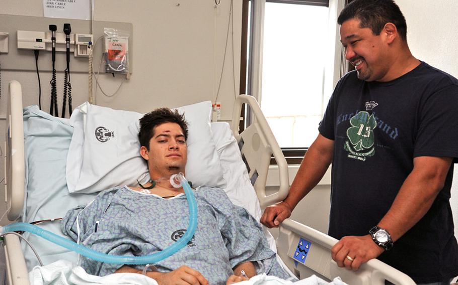 Pvt. Eric Griego gets a visit from his dad Peter in the intensive care ward at Landstuhl Regional Medical Center on Nov. 9. Griego, 22, wounded in Afghanistan, was the first soldier to be flown from a combat zone while being treated with a portable heart-lung machine, known as an extracorporeal membrane oxygenation, or ECMO, machine.