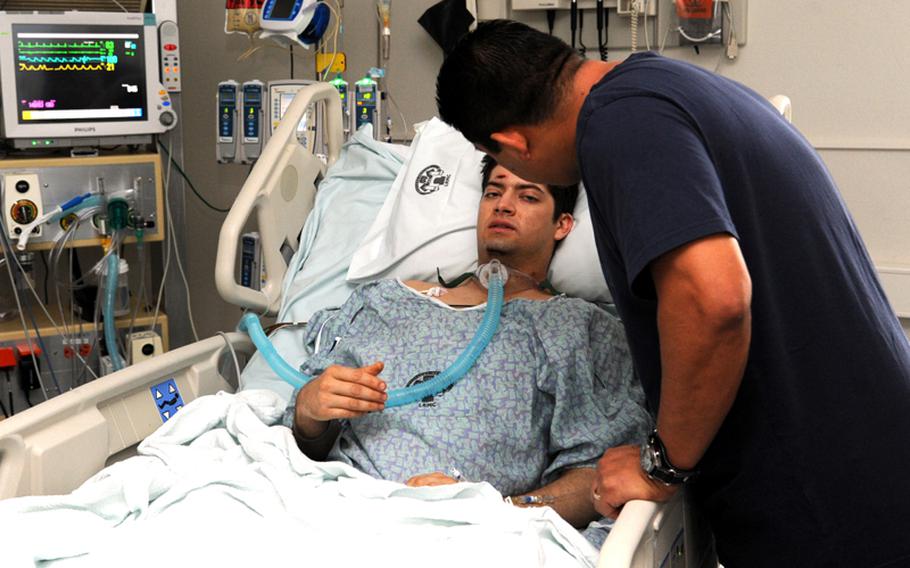 Pvt. Eric Griego talks to his dad Peter in the intensive care ward at Landstuhl Regional Medical Center on Nov. 9. Griego, 22, wounded in Afghanistan was the first soldier to be flown from a combat zone while being treated with a portable heart-lung machine, known as an extracorporeal membrane oxygenation, or ECMO, machine.