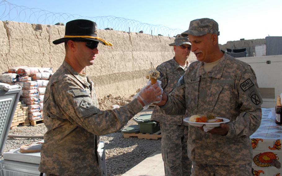 With calls of ''cup or cone'' before soldiers were even through the line getting their Thanksgiving meal, First Sgt. Philip Harrison eagerly scooped cookies-and-cream ice cream for the soldiers of 1/71 Cav. They walked away with plates piled high with yams, turkey and mashed potatoes and and ice cream dripping down their hands.