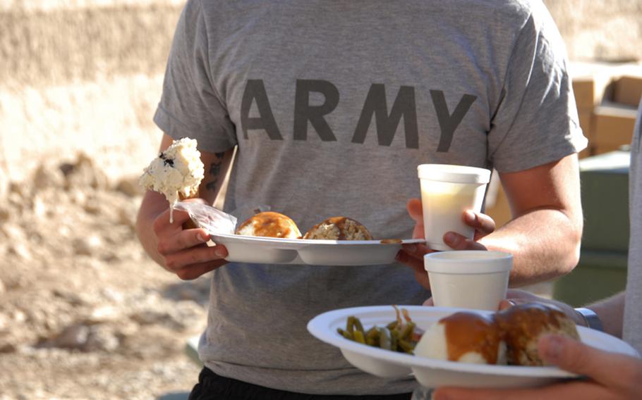 Soldiers with 1st Squadron, 71st Cavalry Regiment, 10th Mountain Division load up plates full of turkey, ham, cornish hens and all the fixings for a Thanksgiving meal in the Dand district of Kandahar, Afghanistan Thursday.