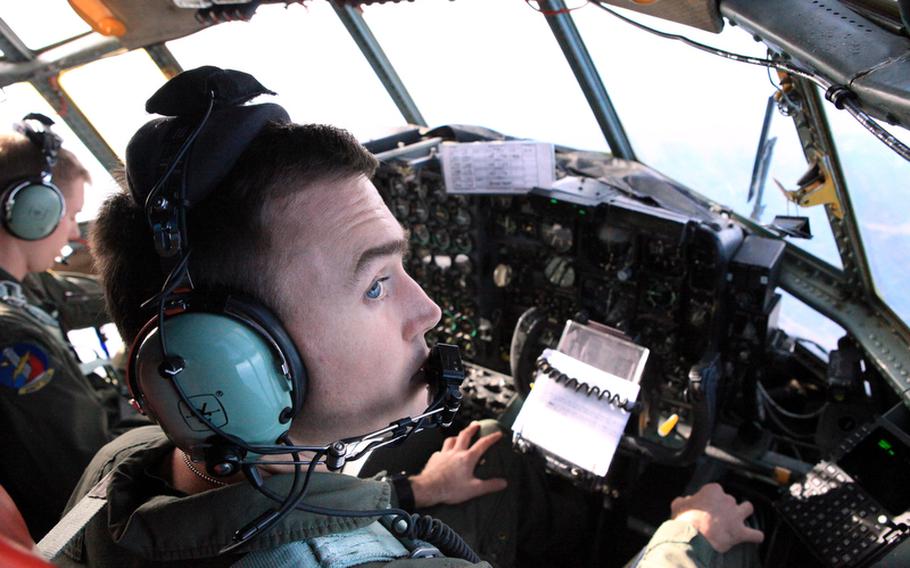 Capt. William Dunn, right, observes the conditions outside his C-130 as it flies toward the Sea of Japan on Monday as part of Keen Sword, a U.S.-Japan training exercise.
