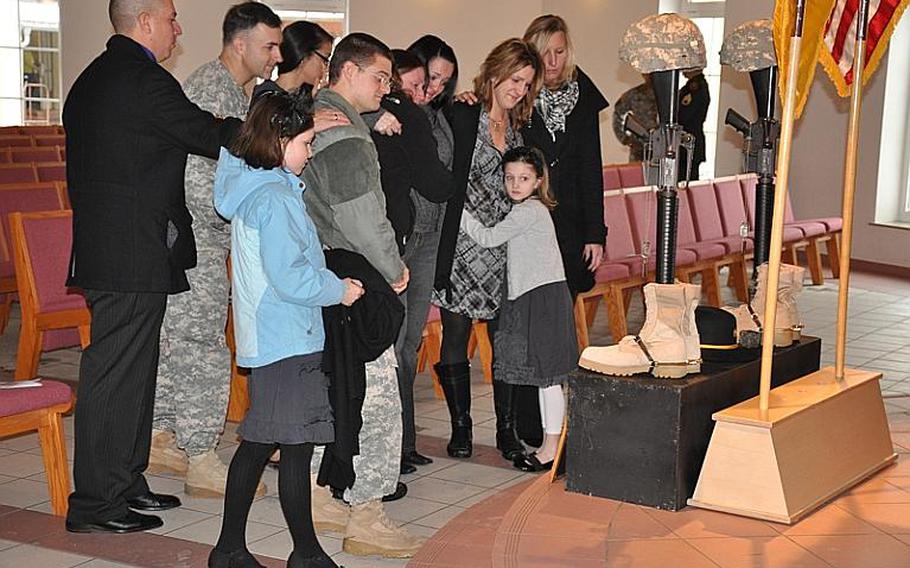 Family and friends of 2nd Stryker Cavalry Regiment soldiers Spc. Kelly J. Mixon and Sgt. James A. Ayube II pay their respects following a memorial service in Vilseck, Germany, on Thursday. Mixon and Ayube were killed Dec. 8 in Balkh province, Afghanistan, from wounds sustained when an insurgent attacked their unit with a bomb, according to a DOD news release.