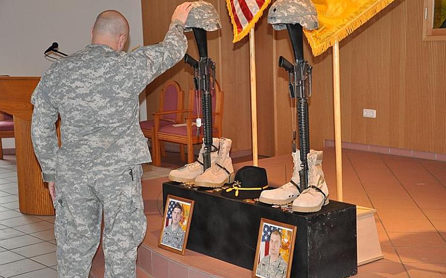 A 2nd Stryker Cavalry Regiment soldier pays his respects to Spc. Kelly J. Mixon and Sgt. James A. Ayube II, following a memorial service in Vilseck on Thursday. Dan Blottenberger/Stars and Stripes
