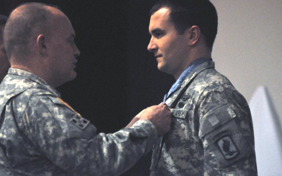 Maj. Gen. David R. Hogg, commander of U.S. Army Africa and the highest ranking Army officer in Italy, pins the Meritorious Service Medal on Staff Sgt. Salvatore Giunta during a ceremony Monday at Caserma Ederle in Vicenza, Italy. Giunta, the lone living recipient of the Medal of Honor from the war in Afghanistan, will be leaving the 173rd Airborne Brigade Combat Team this week and will be out of the Army in June.
Kent Harris/Stars and Stripes