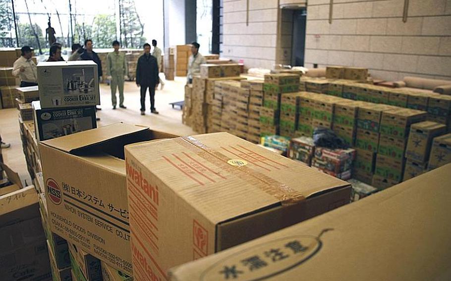 Workers prepare to load an inbound cargo truck with supplies bound for evacuation sites throughout the area at the Sendai Prefectural Headquarters Building, in Sendai City.