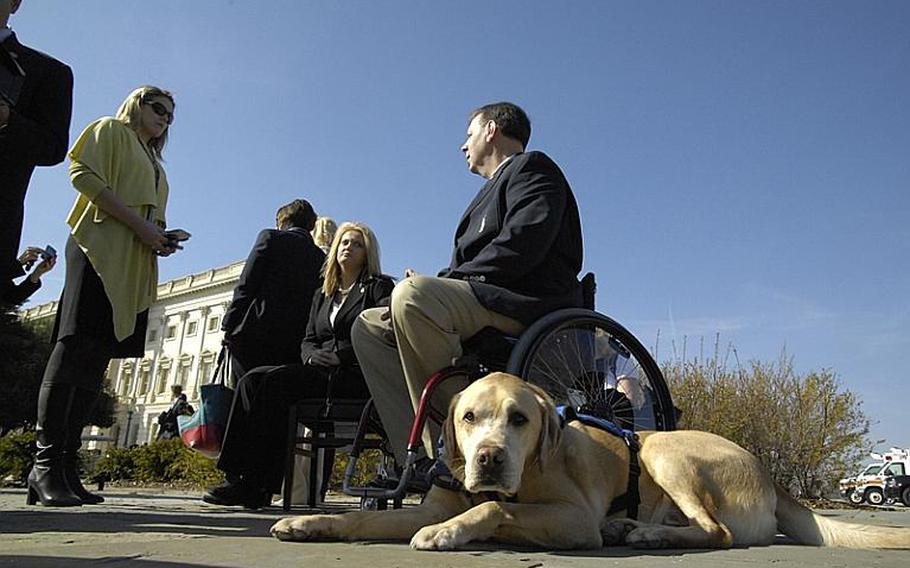 Kevin Stone and his service dog, Mambo, wait outside the Capitol following a press conference Thursday. New legislation introduced Thursday would allow service dogs inside VA medical facilities, a decision that's currently left to the discretion of the facility managers.