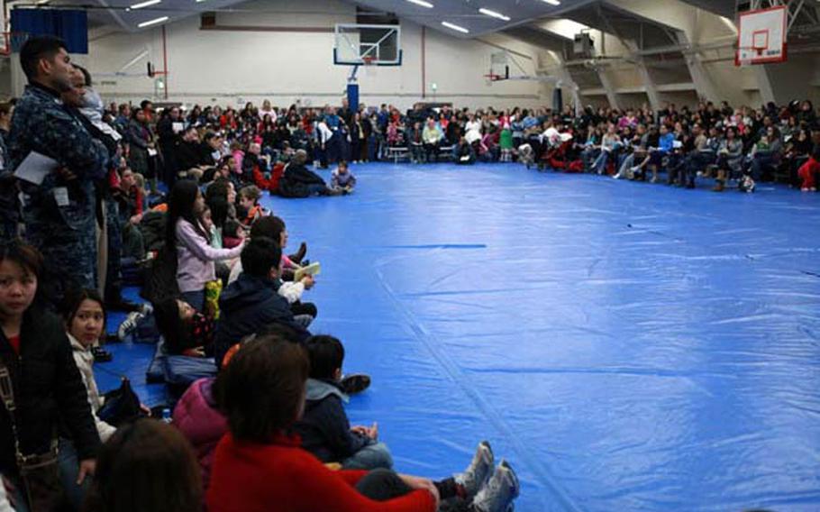 Large crowds gather Friday at Halsey Gym at Naval Air Facility Atsugi, Japan, to find out more information about the voluntary evacuation. Planes carrying family memebers are expected to start leaving Japan this weekend.